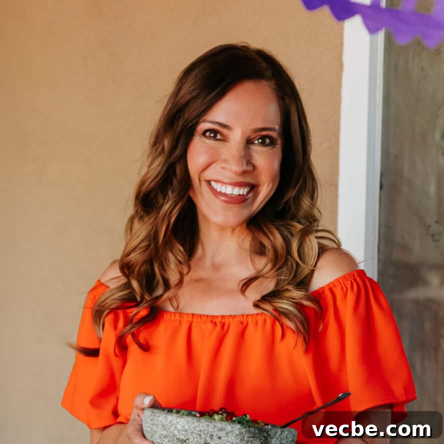 How to Make Mexican Chamoy Sauce at Home 4 Yvette Marquez muy bueno Mexican food blogger in an orange dress holding a molcajete.