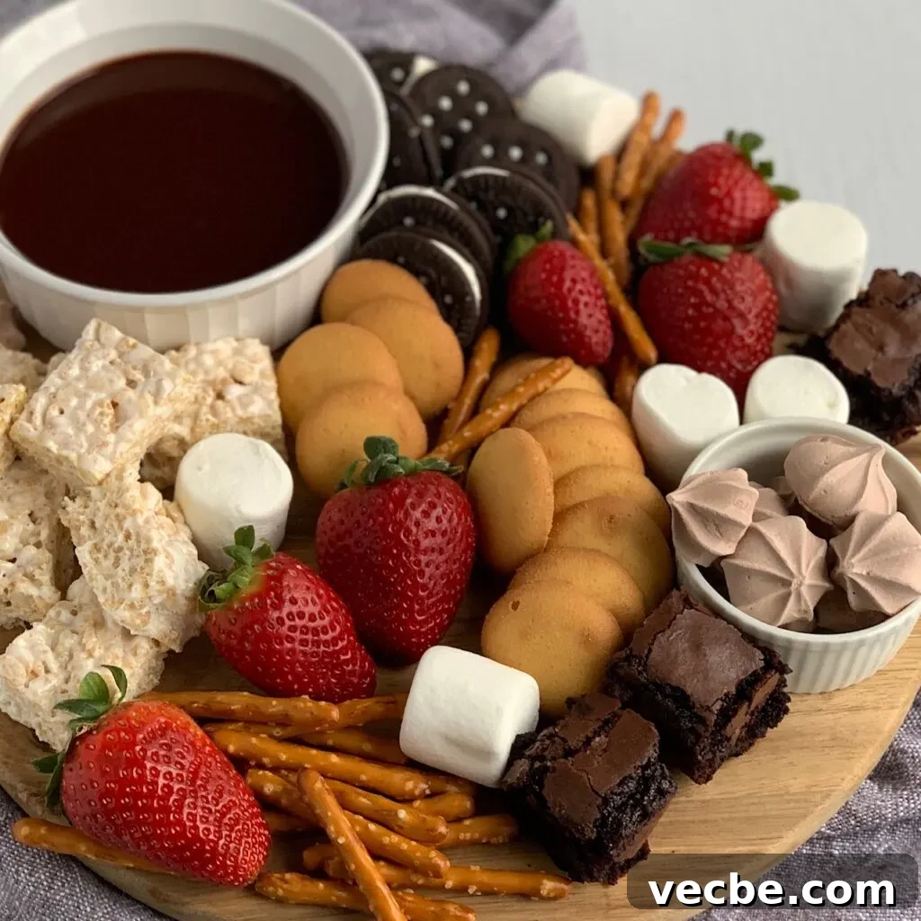 Romantic Valentine's Day Recipes for Two 6 A serving board filled with amzing items such as mini rice krispies, mini brownie bites, safe oreos, pretzels, vanilla wafers, large marshmallows, strawberries and a small bowl of chocolate ganache dipping sauce.