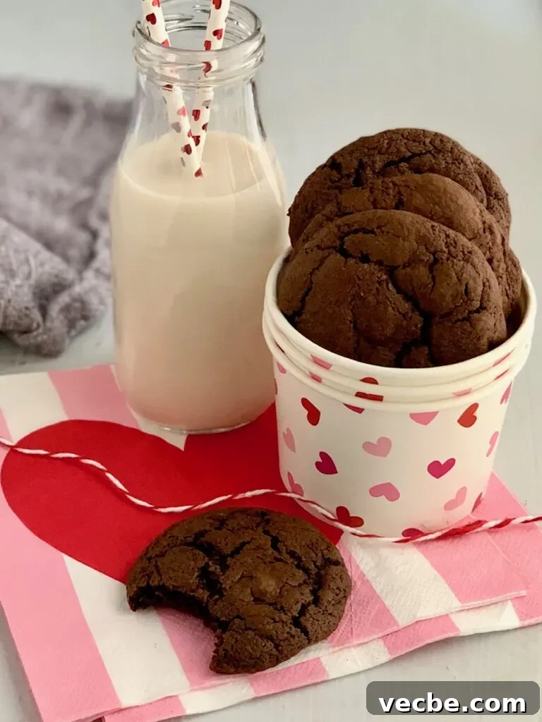 Romantic Valentine's Day Recipes for Two 4 Round brownie cookies with a bite eaten out of one next to a glass of dairy free milk.