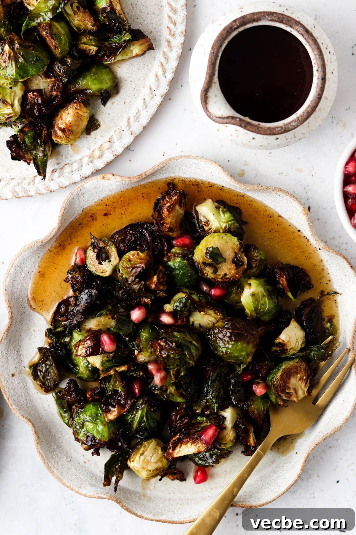 maple brussel sprouts 1.4 Balsamic maple brussel sprouts on a plate with a gold fork.