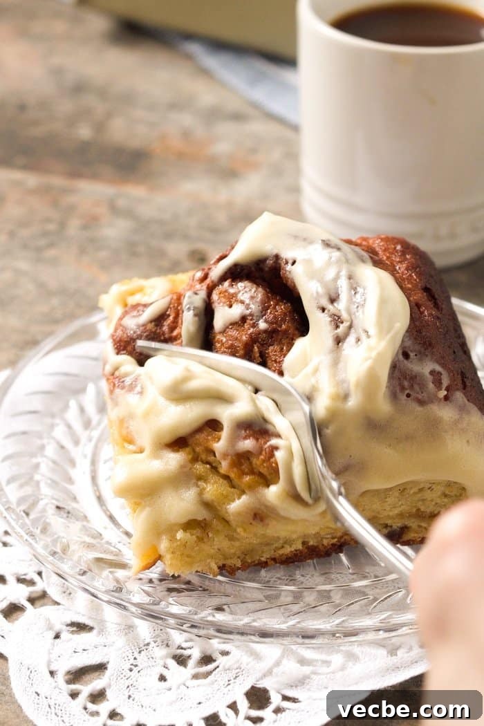Fluffy Paleo and Keto Cinnamon Rolls Recipe with Yeast 9 Cutting a fluffy Keto cinnamon roll with a fork