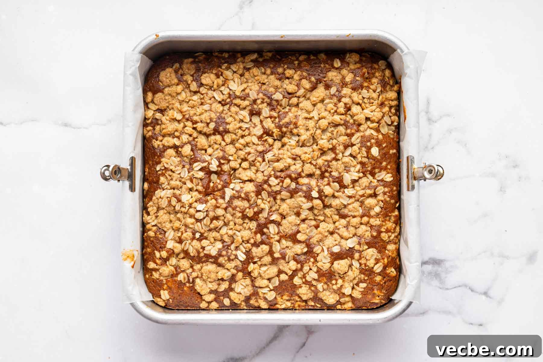 Pumpkin Coffee Cake Recipe with Cinnamon Streusel 6 Freshly baked pumpkin coffee cake with crumb topping in a square pan.