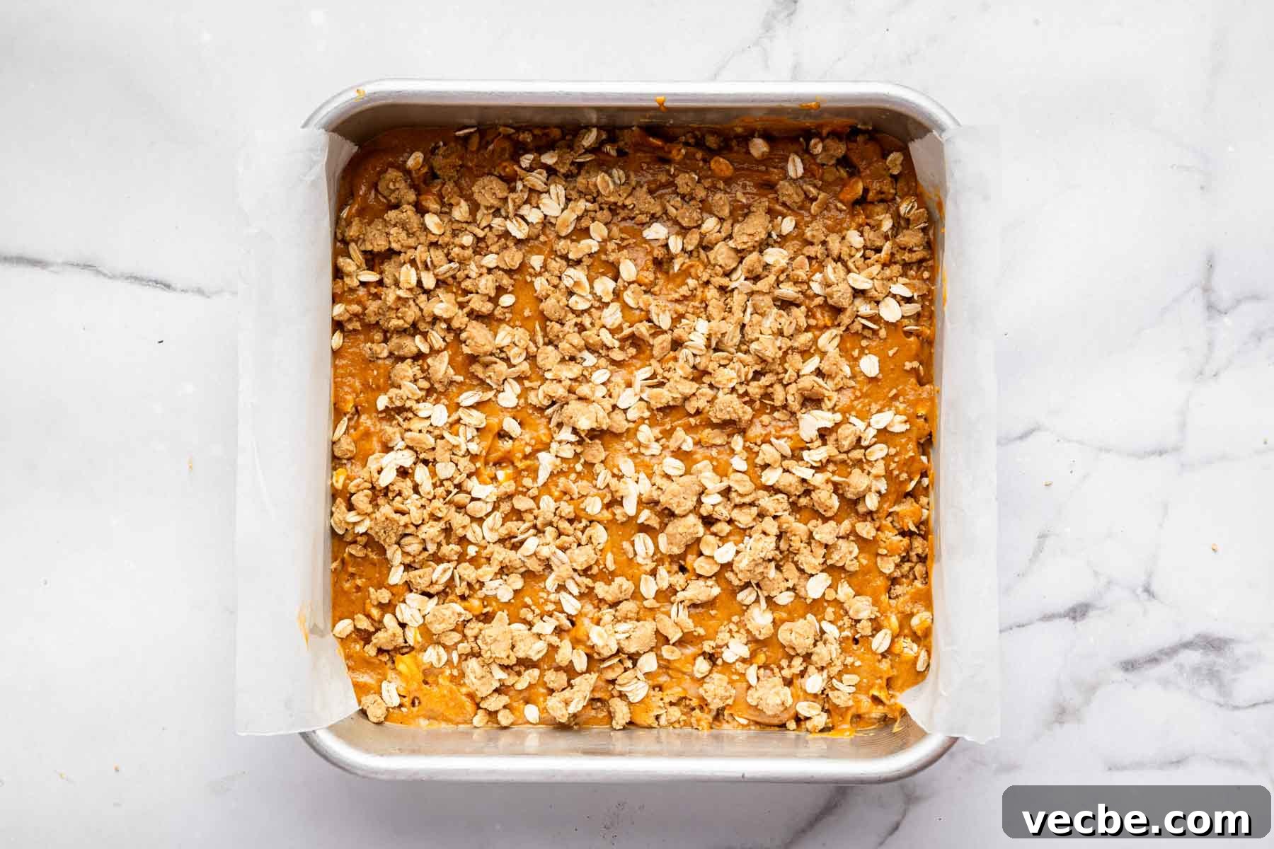 Pumpkin Coffee Cake Recipe with Cinnamon Streusel 5 Pumpkin coffee cake with crumb topping in a square pan before baking.