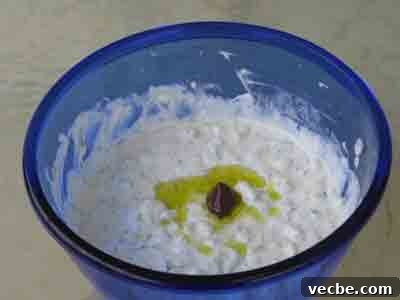 Authentic Greek Tzatziki Sauce 3 Tsatsiki garnished with an olive and some olive oil.