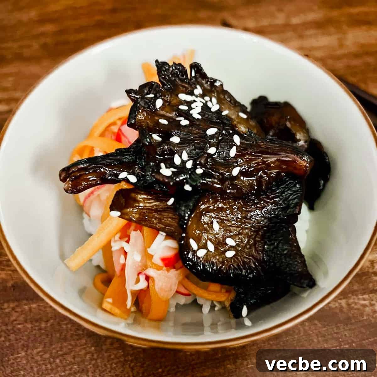 Quick Chinese Pickled Cucumbers Recipe 15 Photo of a small bowl filled with some sushi rice, pickled shredded vegetables and Char Siu mushrooms on top.