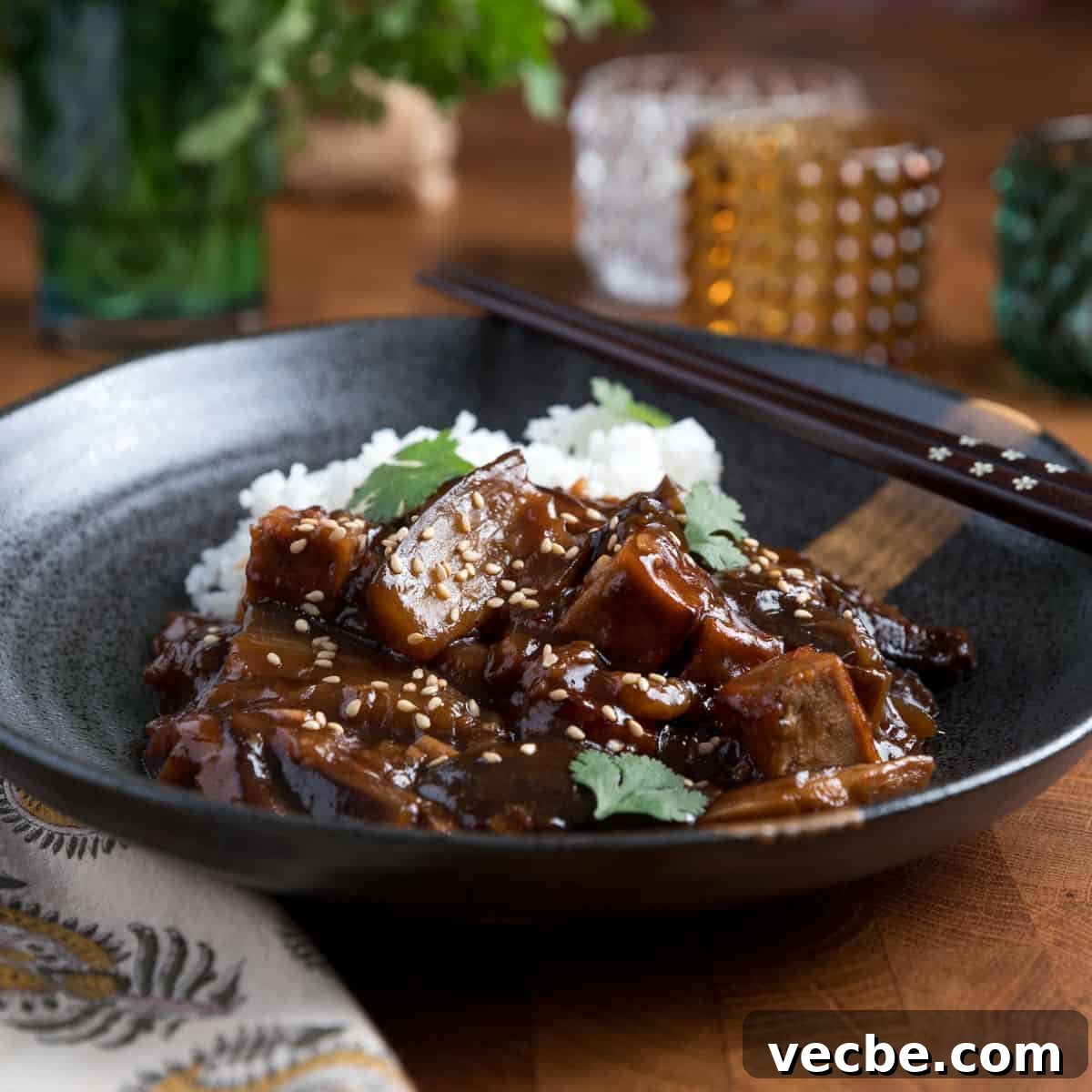 Quick Chinese Pickled Cucumbers Recipe 16 Photo of Chinese braised aubergine and tofu with rice in a black bowl with chopsticks.