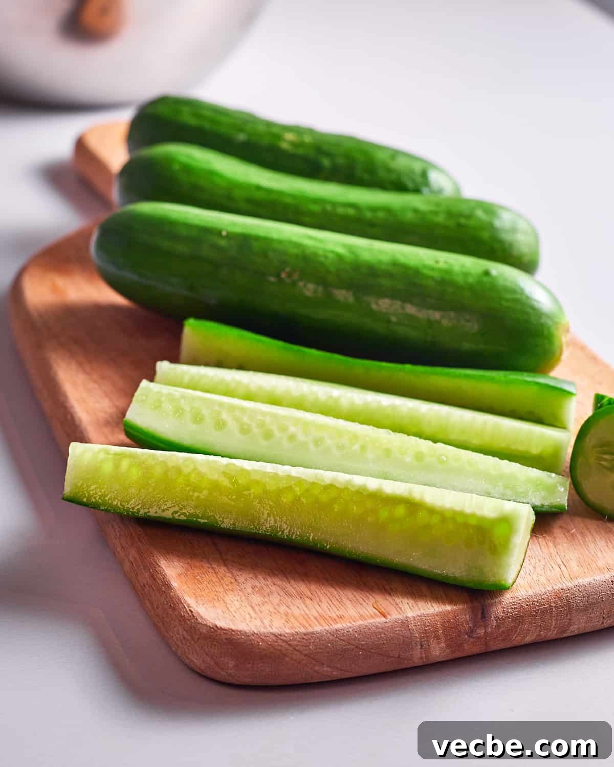 Quick Chinese Pickled Cucumbers Recipe 5 Photo of cucumbers cut to the right size on a wooden chopping board.