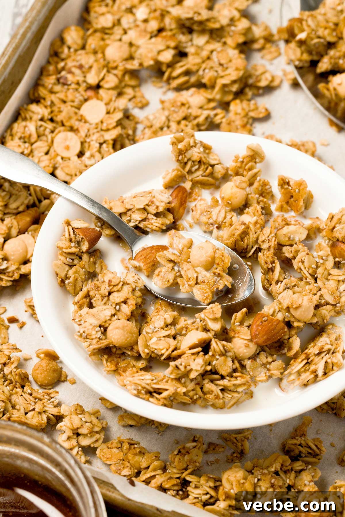 White Chocolate Vanilla Almond Granola 4 A close-up of a small white bowl with vanilla almond granola and white chocolate chips in milk.