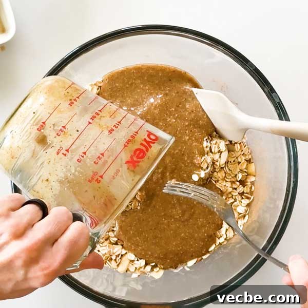 White Chocolate Vanilla Almond Granola 8 Pouring wet ingredients into the granola mixture.