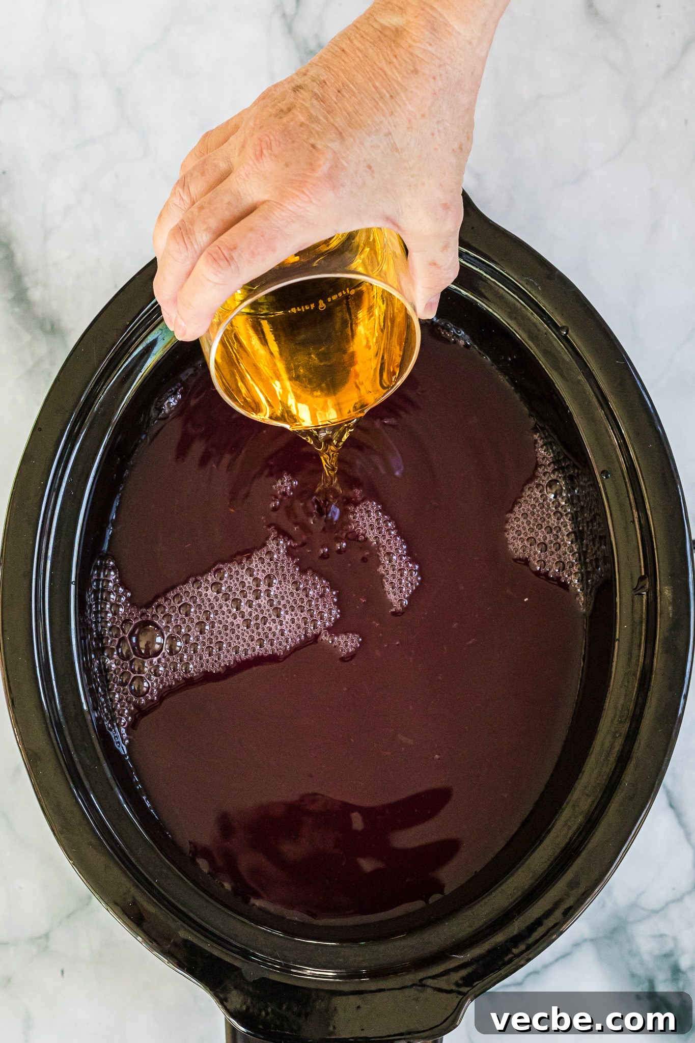 Slow Cooker Spiked Wassail: Festive Mulled Cider 5 pour juice into a slow cooker for wassail