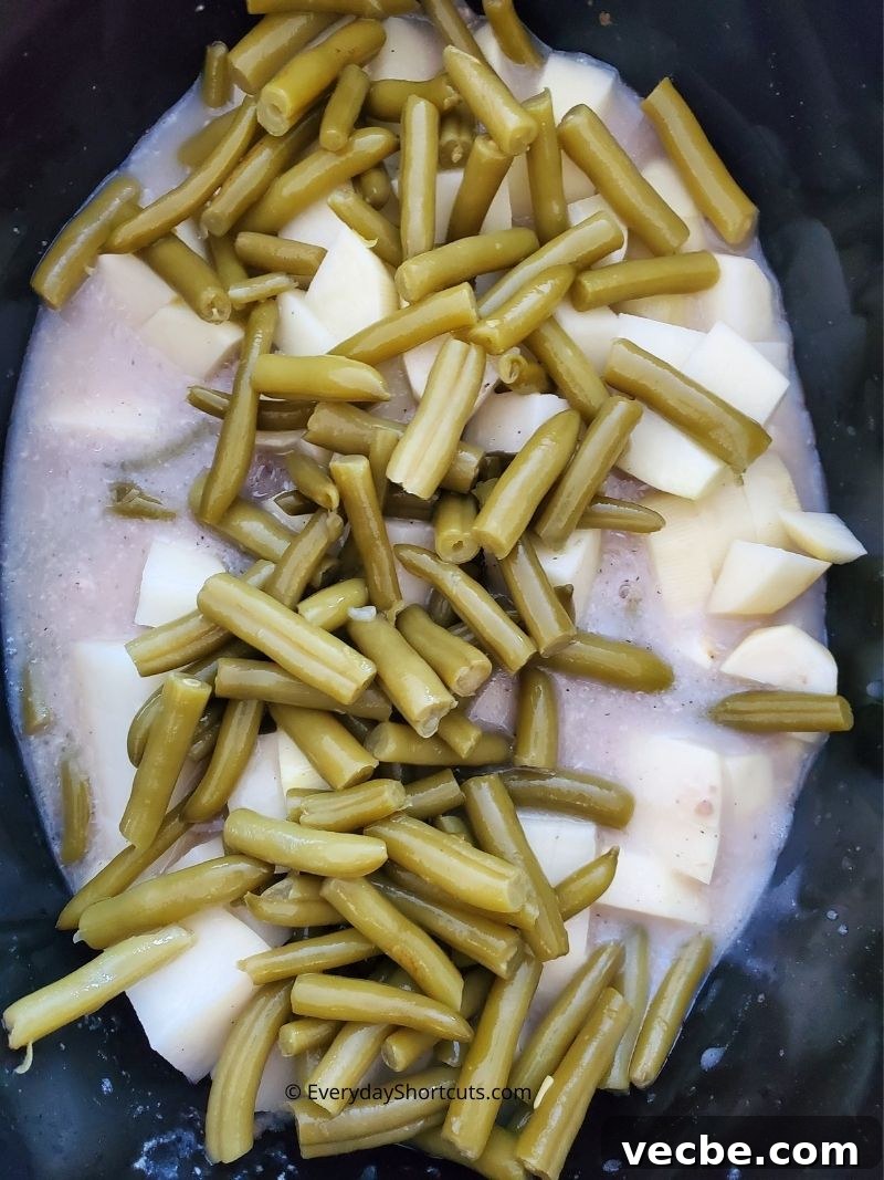 Slow Cooker Pork Chops with Potatoes and Green Beans 7 Pork chops cooking in creamy mushroom gravy