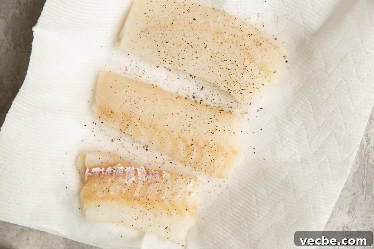 Pan-Fried Mediterranean Cod with Lemon, Olives and Tomatoes 4 Three fresh cod filets on a plate lined with paper towels, sprinkled with salt and pepper.