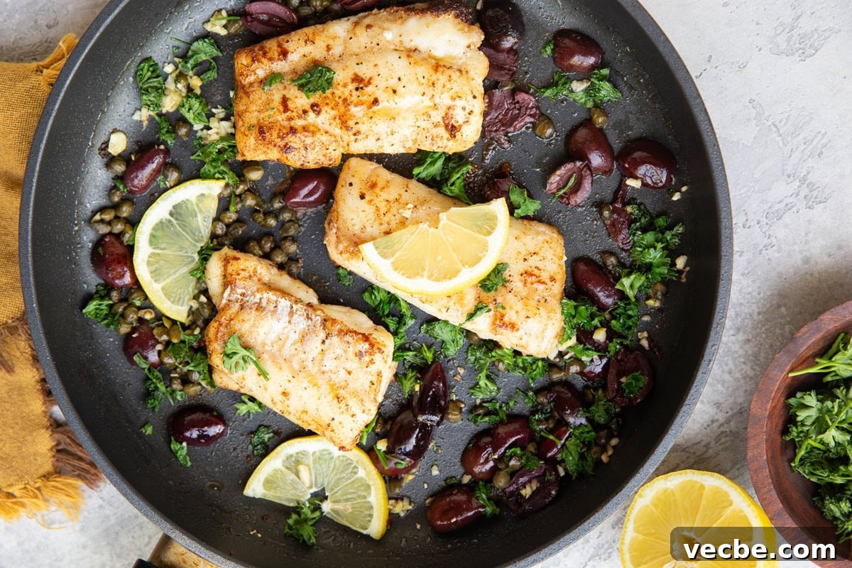 Pan-Fried Mediterranean Cod with Lemon, Olives and Tomatoes 6 Three pan-fried cod filets in a skillet with fresh lemons, kalamata olives, capers, and parsley. A bowl of fresh parsley to the side.