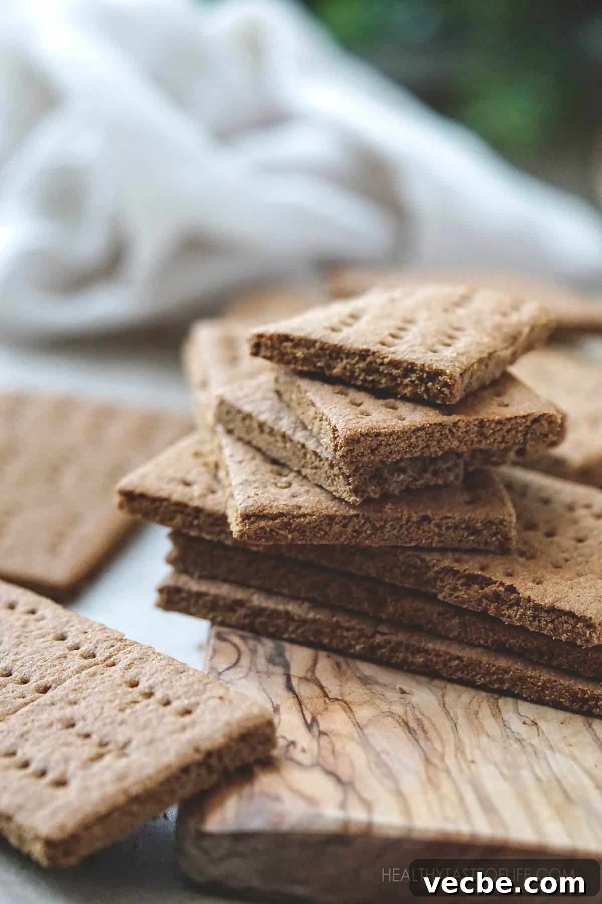 Gluten Free Vegan Graham Crackers Recipe 9 Homemade gluten-free vegan graham crackers stacked on a wooden board showing crisp texture