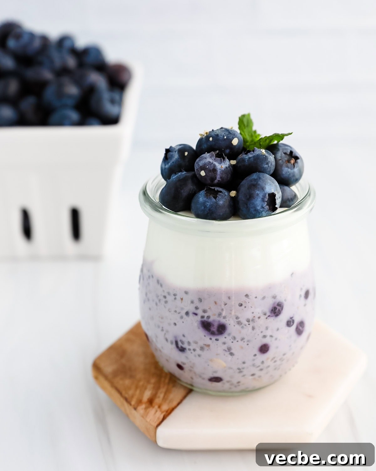 Creamy Blueberry Overnight Oats Recipe 6 Blueberry chia seed oats in a jar with a layer of vanilla yogurt and blueberries on top.