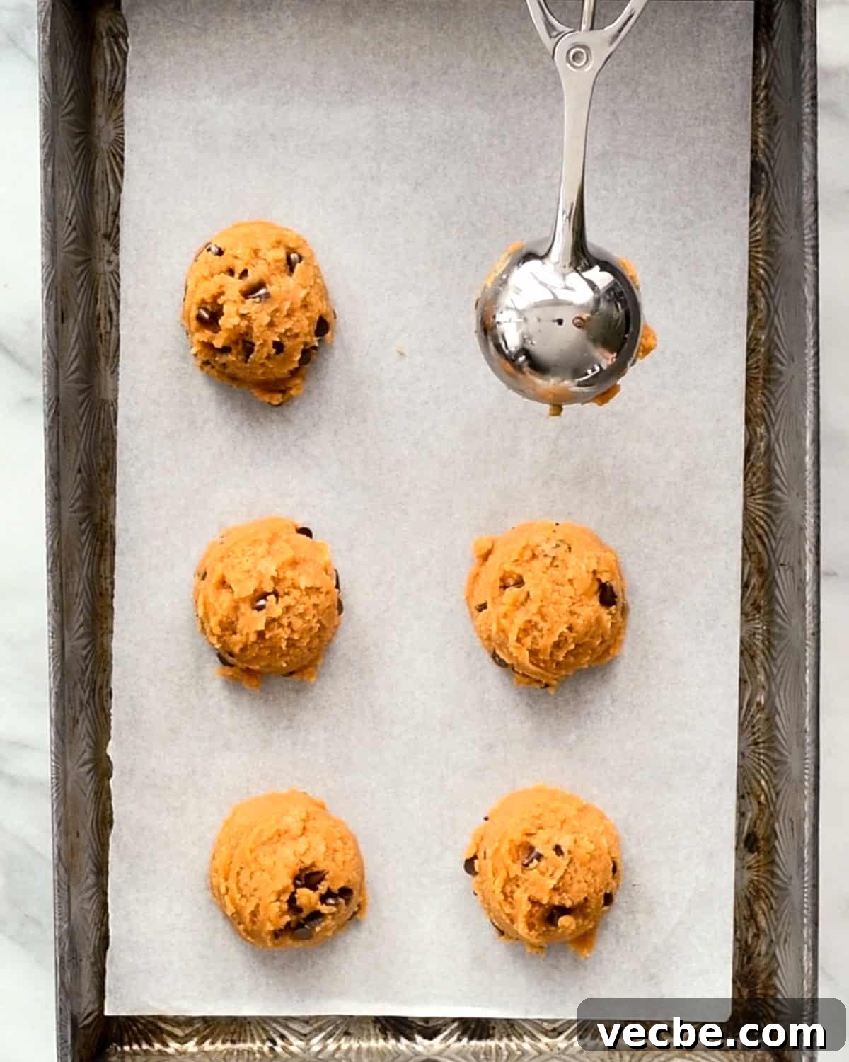 Gluten Free Peanut Butter Blossoms Recipe 7 a cookie scoop measuring dough onto a baking sheet