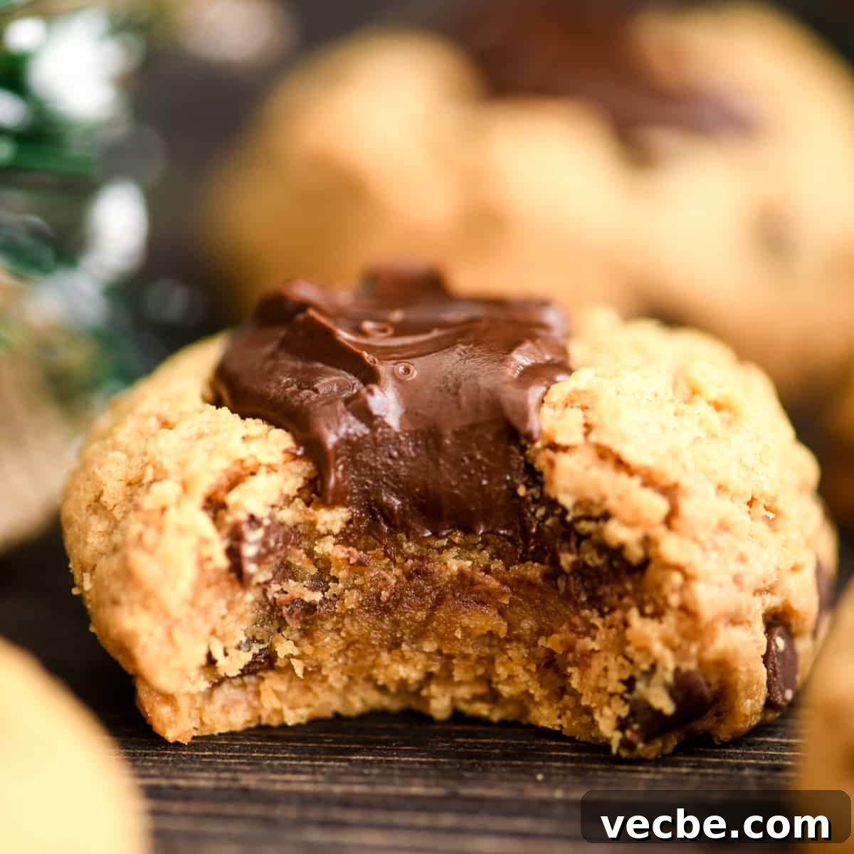 Gluten-Free Peanut Butter Blossoms a Gluten Free Peanut Butter Blossom cookie with a bite taken out of it