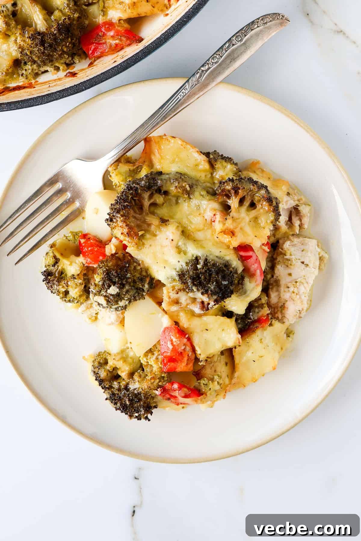 Creamy Baked Chicken, Broccoli and Potato Casserole 7 Chicken broccoli and potato casserole on a plate with a fork.