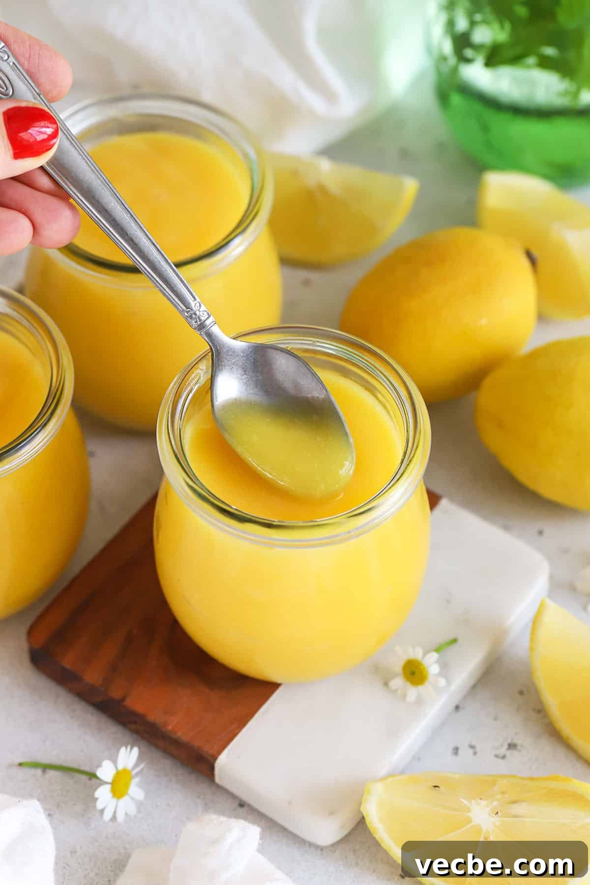 Homemade Lemon Curd Recipe: Ready in 20 Minutes 7 a spoon scooping homemade lemon curd from a jar