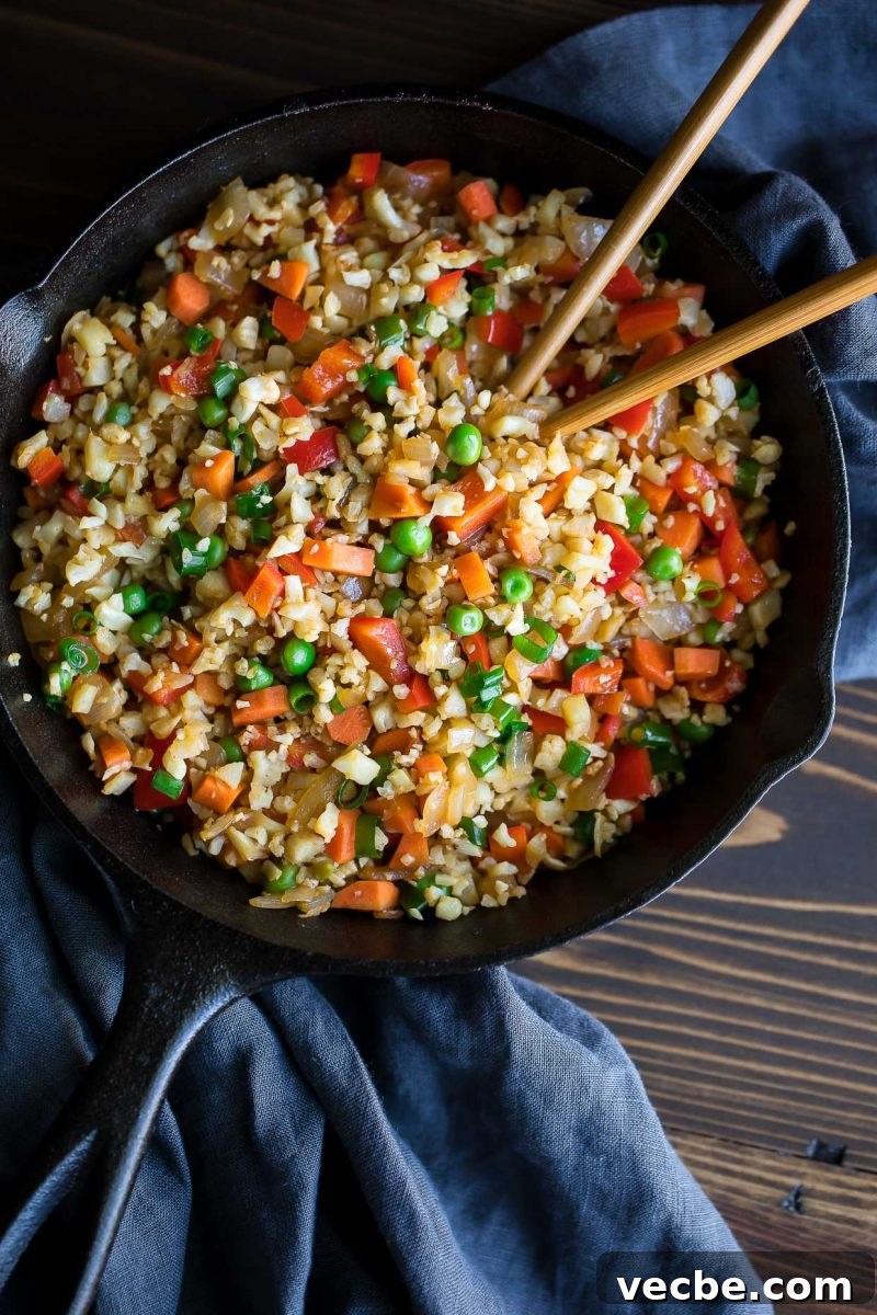 Vegan Cauliflower Fried Rice Recipe 4 Vegan Cauliflower Fried Rice in a cast iron skillet with chopsticks