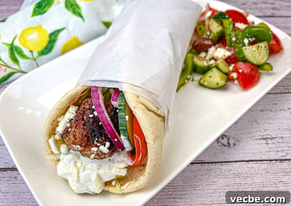 25 Ground Beef Recipes for Real Weeknight Dinners 16 Greek Meatball Pita Sandwich served on a white rectangular plate.