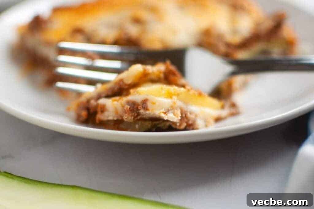 25 Ground Beef Recipes for Real Weeknight Dinners 6 A close-up, slightly high-angle view of Zucchini Lasagna squares arranged on a dark gray baking sheet, each topped with a glossy, light brown apple filling and a generous sprinkle of light brown crumb topping.