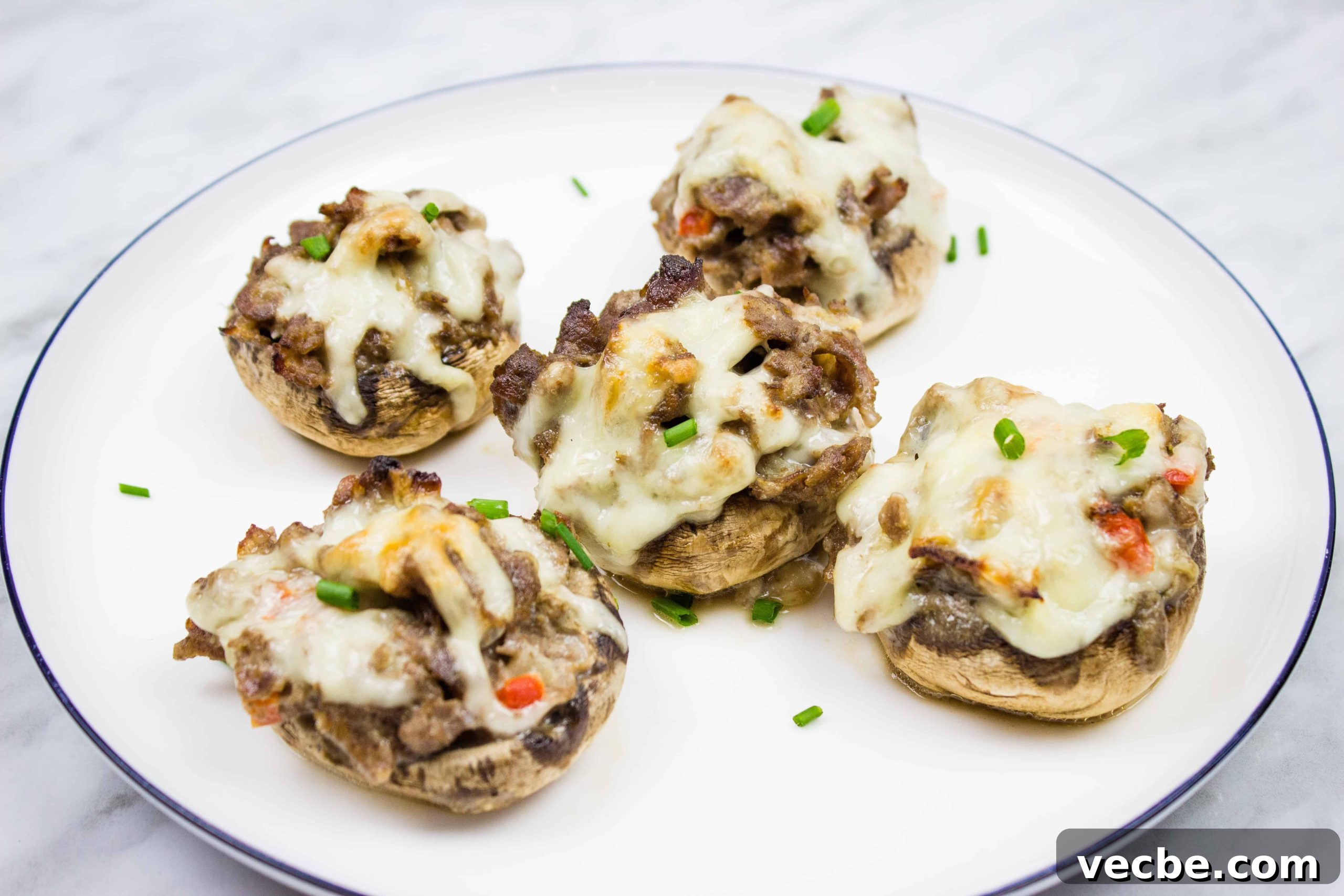 25 Ground Beef Recipes for Real Weeknight Dinners 7 Four stuffed mushrooms on a white plate.