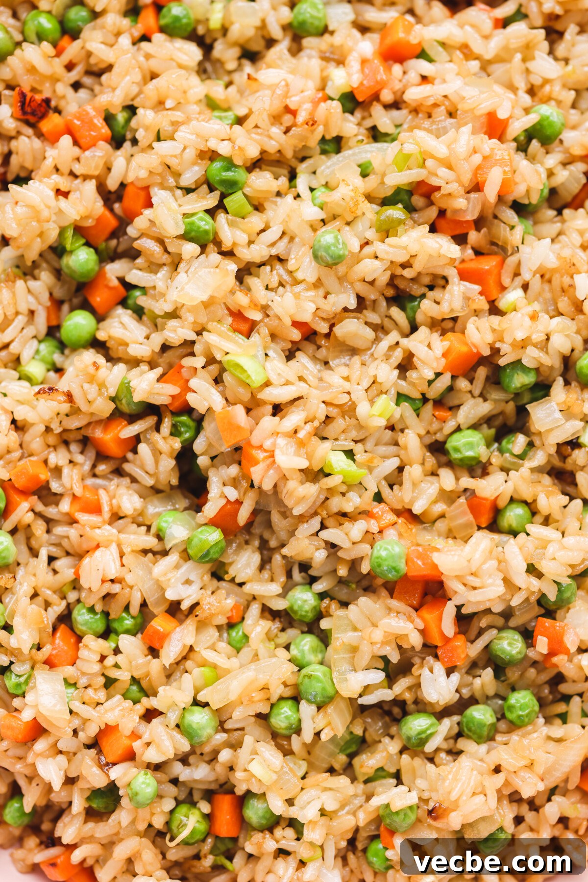Vegan Fried Rice Recipe That Tastes Like Takeout 3 a close up of cooked rice with peas, carrots, and onions
