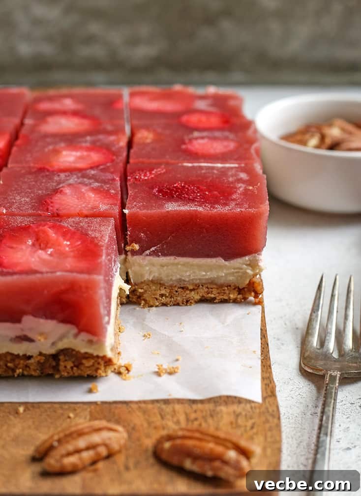 No Bake Paleo Strawberry Pretzel Salad Recipe 3 slices of paleo strawberry pretzel salad. One piece removed to show the layers of crust, cream cheese and gelatin.