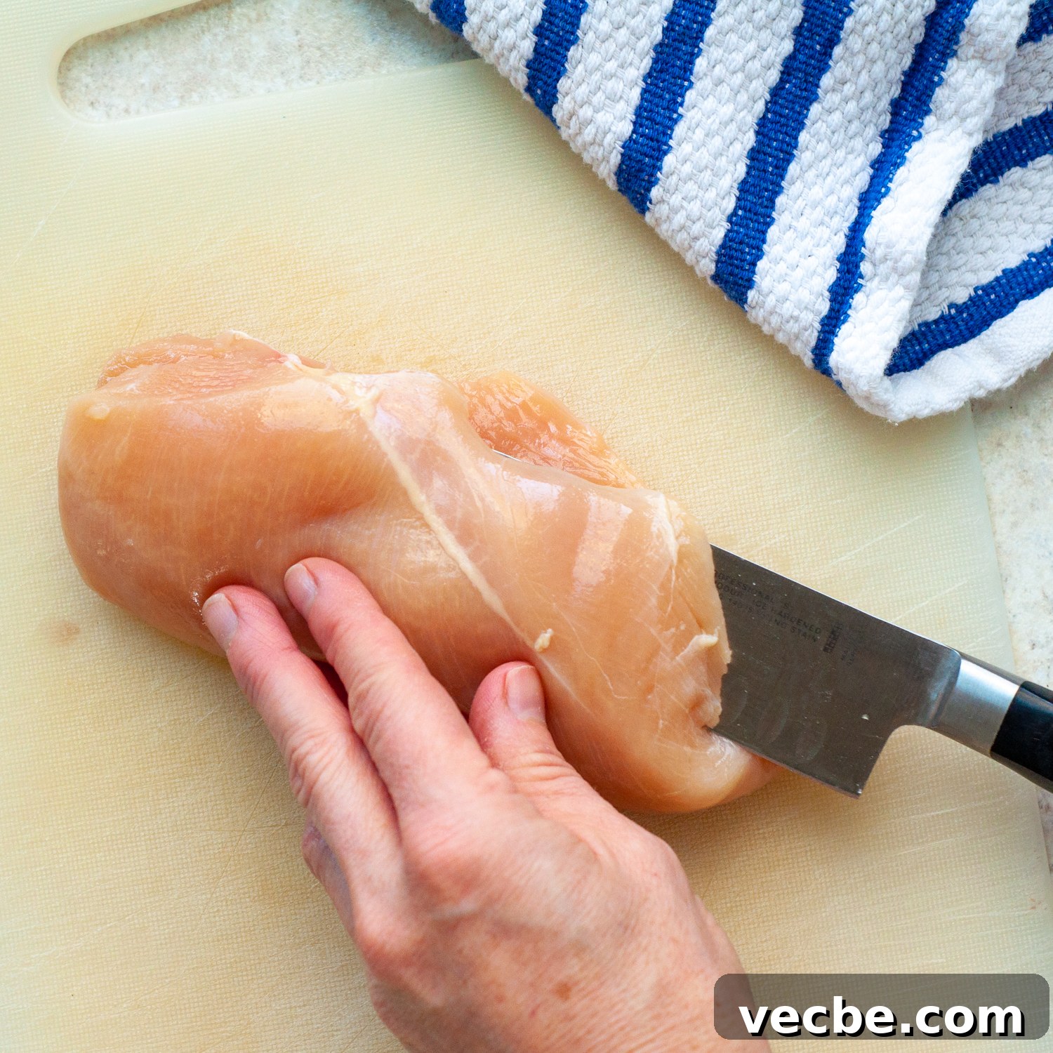 Buffalo Chicken Bake with Tortilla Chip Crust 3 a knife cutting a chicken breast into a thinner cutlet.