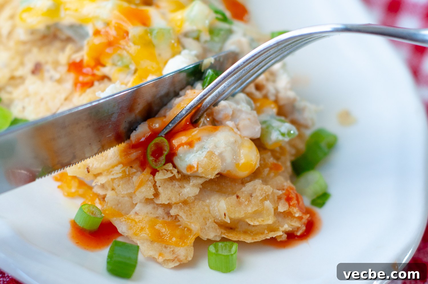 Buffalo Chicken Bake with Tortilla Chip Crust 9 a fork cutting into a serving of chicken.
