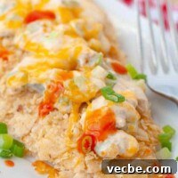 Buffalo Chicken Bake with Tortilla Chip Crust 10 baked buffalo chicken on a white plate with a fork resting nearby