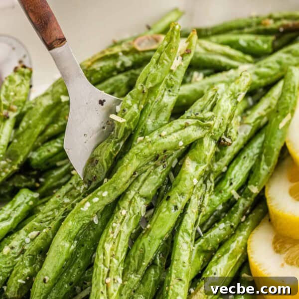 Crispy Buttered Air Fryer Corn on the Cob 12 Air fryer green beans on a fork.