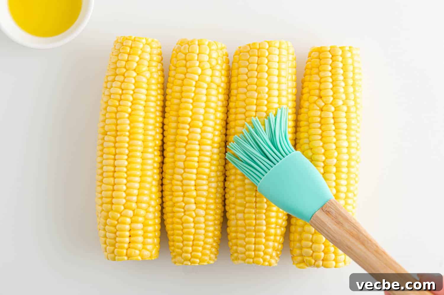 Crispy Buttered Air Fryer Corn on the Cob 5 A rubber basting brush is used to brush ears of corn with olive oil.