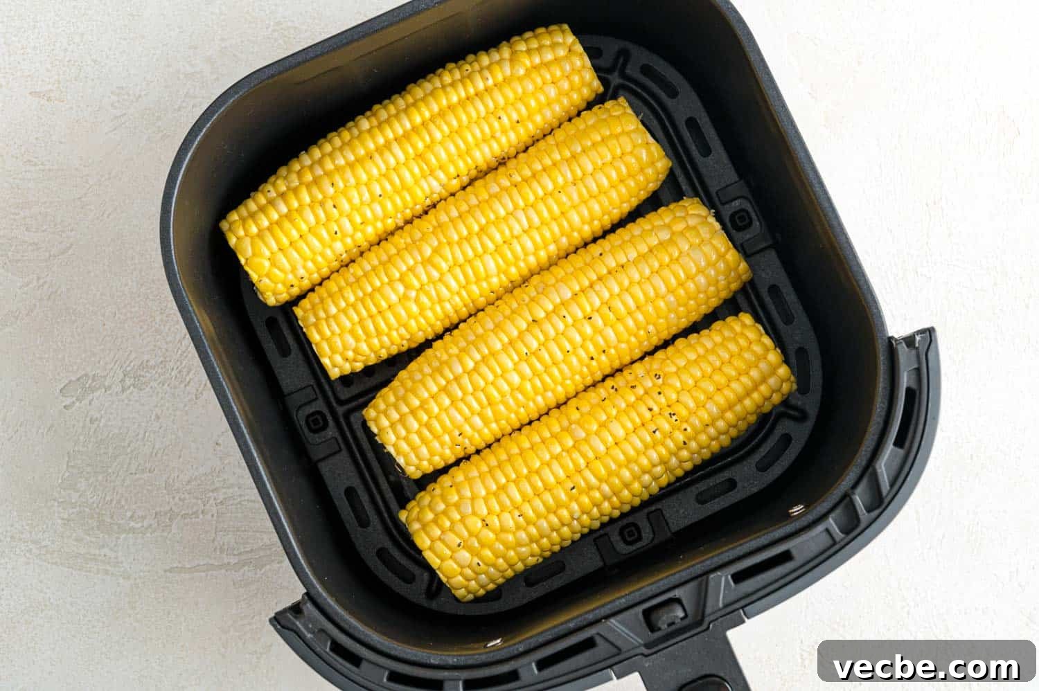 Crispy Buttered Air Fryer Corn on the Cob 6 Four ears of corn inside the air fryer.