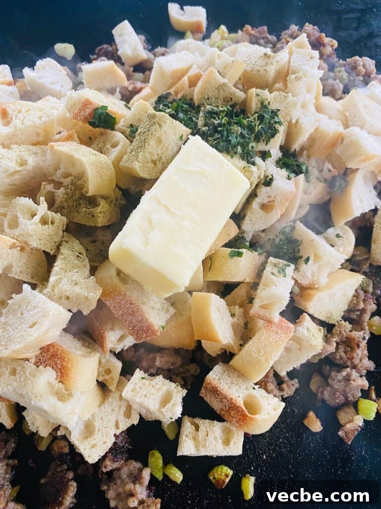 Crispy Sausage and Cranberry Stuffing on a Blackstone Griddle 8 adding bread seasoning and butter