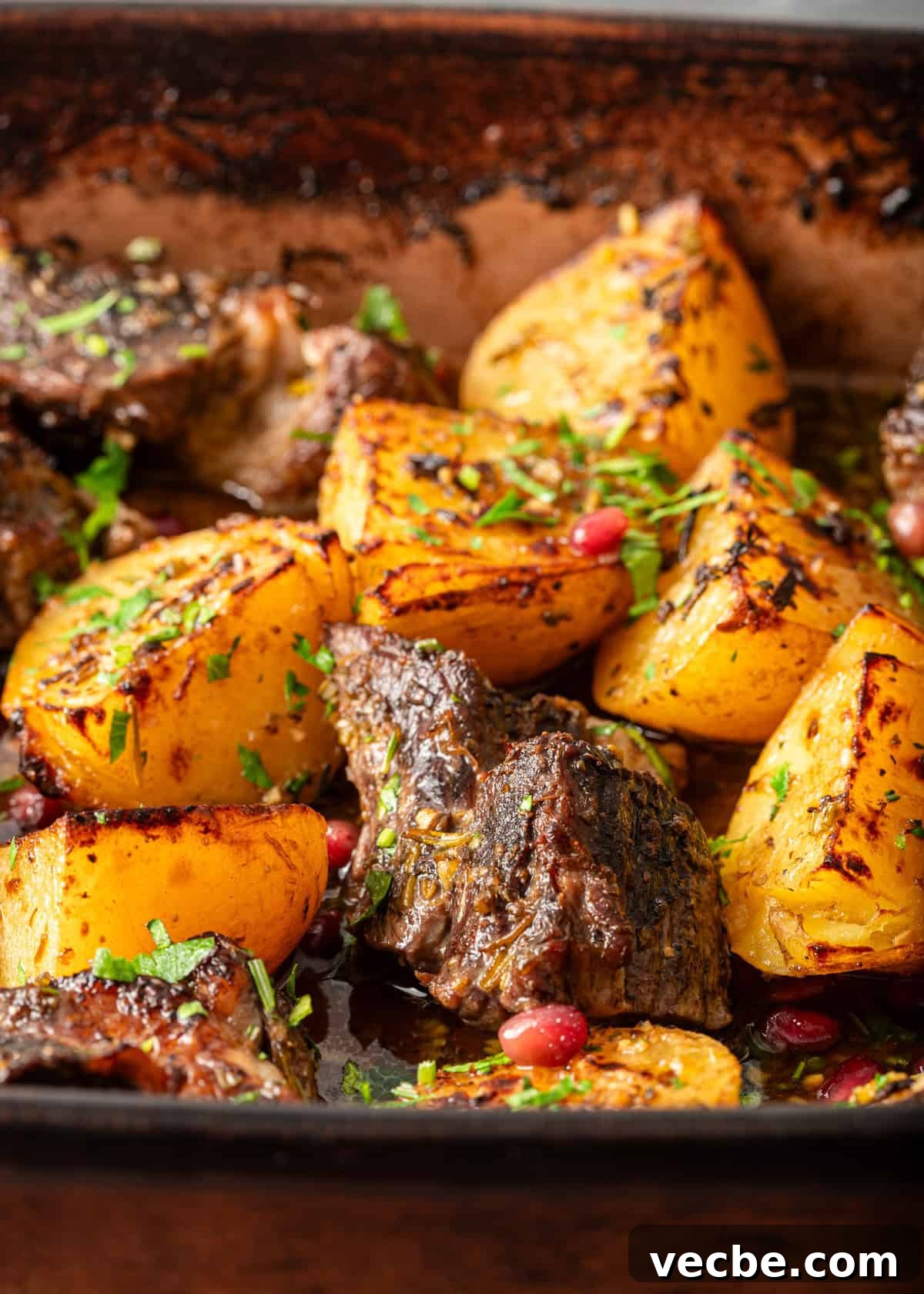 Greek Lemon Pot Roast with Crispy Potatoes 7 closeup: roasted beef chuck with potatoes in a baking dish
