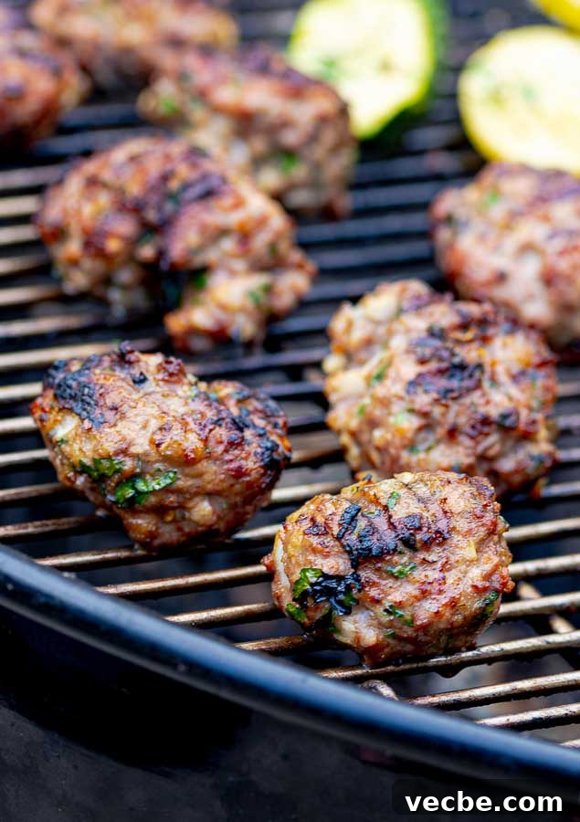 Grilled Italian Meatballs Recipe 2 two grilled homemade Italian meatballs in the front on the grill